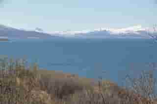 Meer mit schneebedeckten Bergen im Hintergrund. Fotografiert in Narvik.