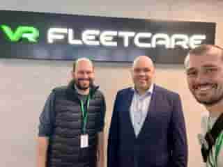 3 Personen vor einem Schriftzug