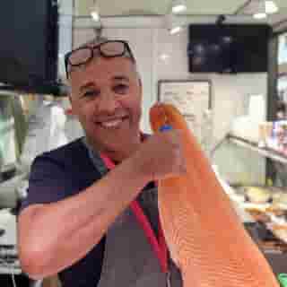 Fischhändler mit Lachs in der Markthalle