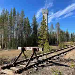Prellbock mit Betonturm im Hintergrund