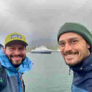 Zwei Reisende mit Fähre im Hintergrund