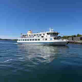 Das weisse Schärenfährschiff Silvertärnan fährt bei blauem Himmel durch die Göteborger Schären.