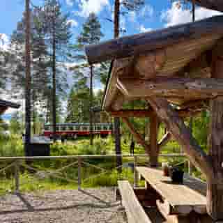 Triebwagen der Inlandsbanan steht unterhalb eines Restaurants im Birkenwald.