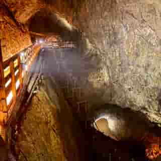 Grosse Kammer mit Schächten in mehrere Richtungen im Bergwerk.