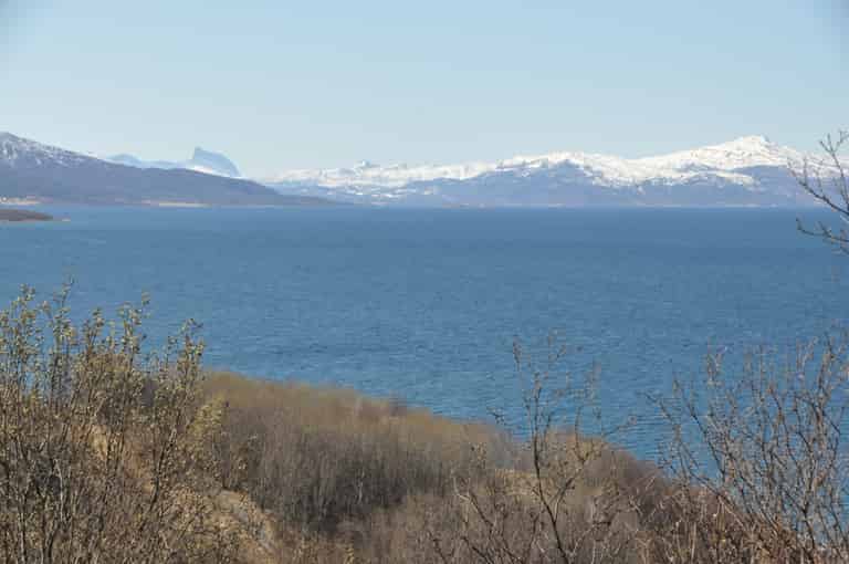 Meer mit schneebedeckten Bergen im Hintergrund. Fotografiert in Narvik.