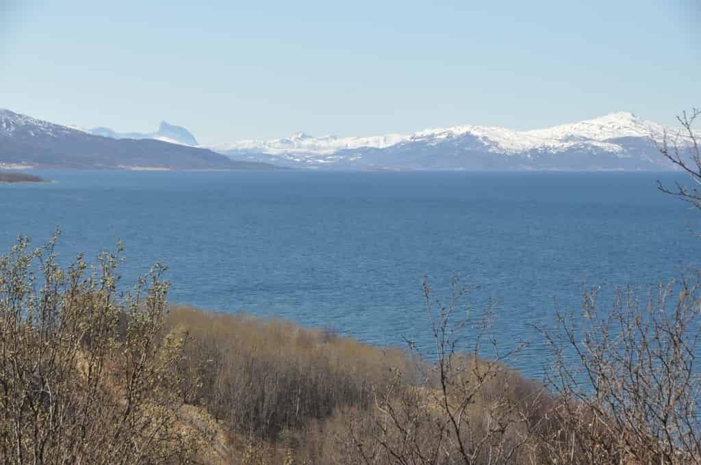 Meer mit schneebedeckten Bergen im Hintergrund. Fotografiert in Narvik.