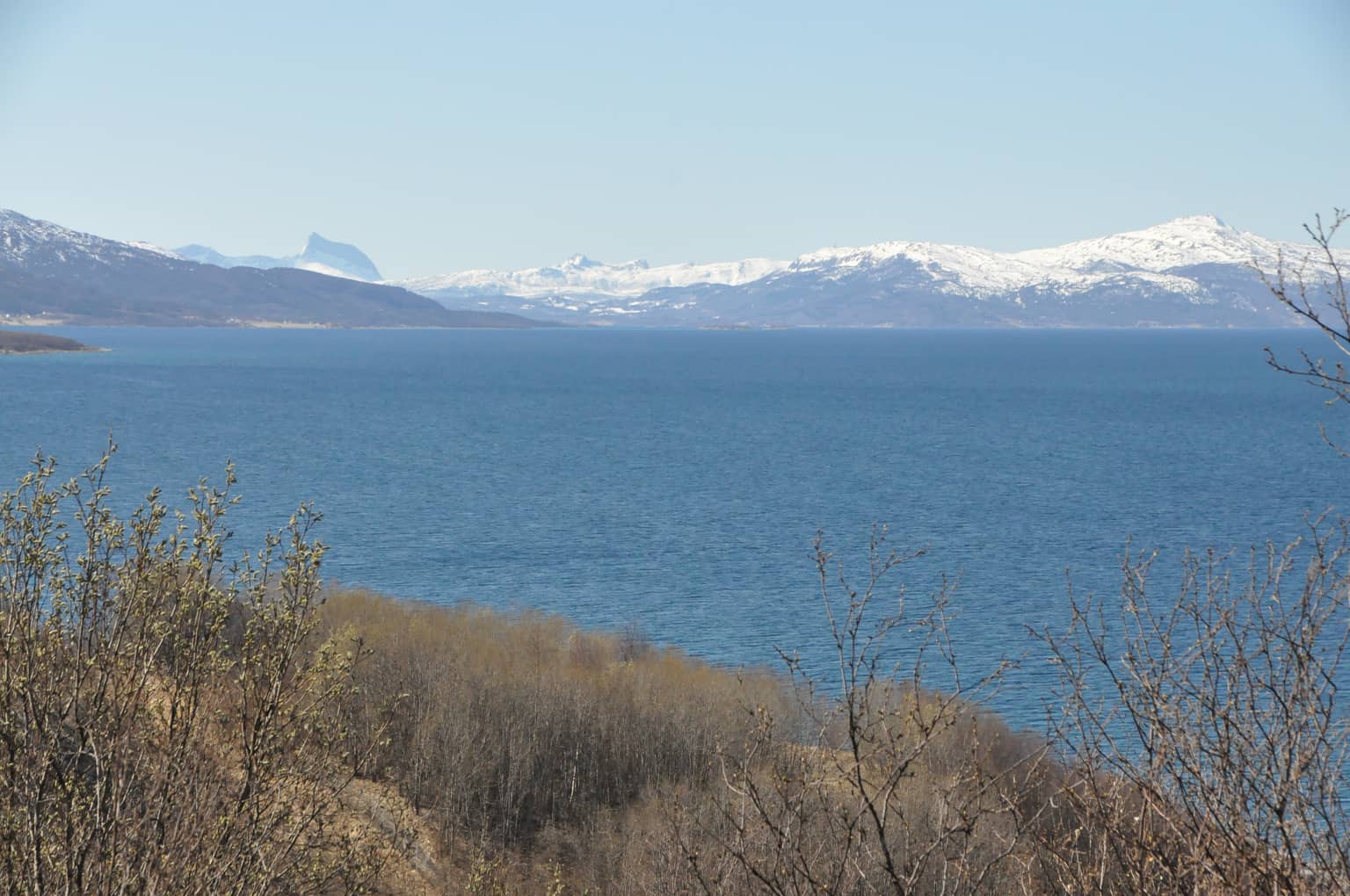 Meer mit schneebedeckten Bergen im Hintergrund. Fotografiert in Narvik.