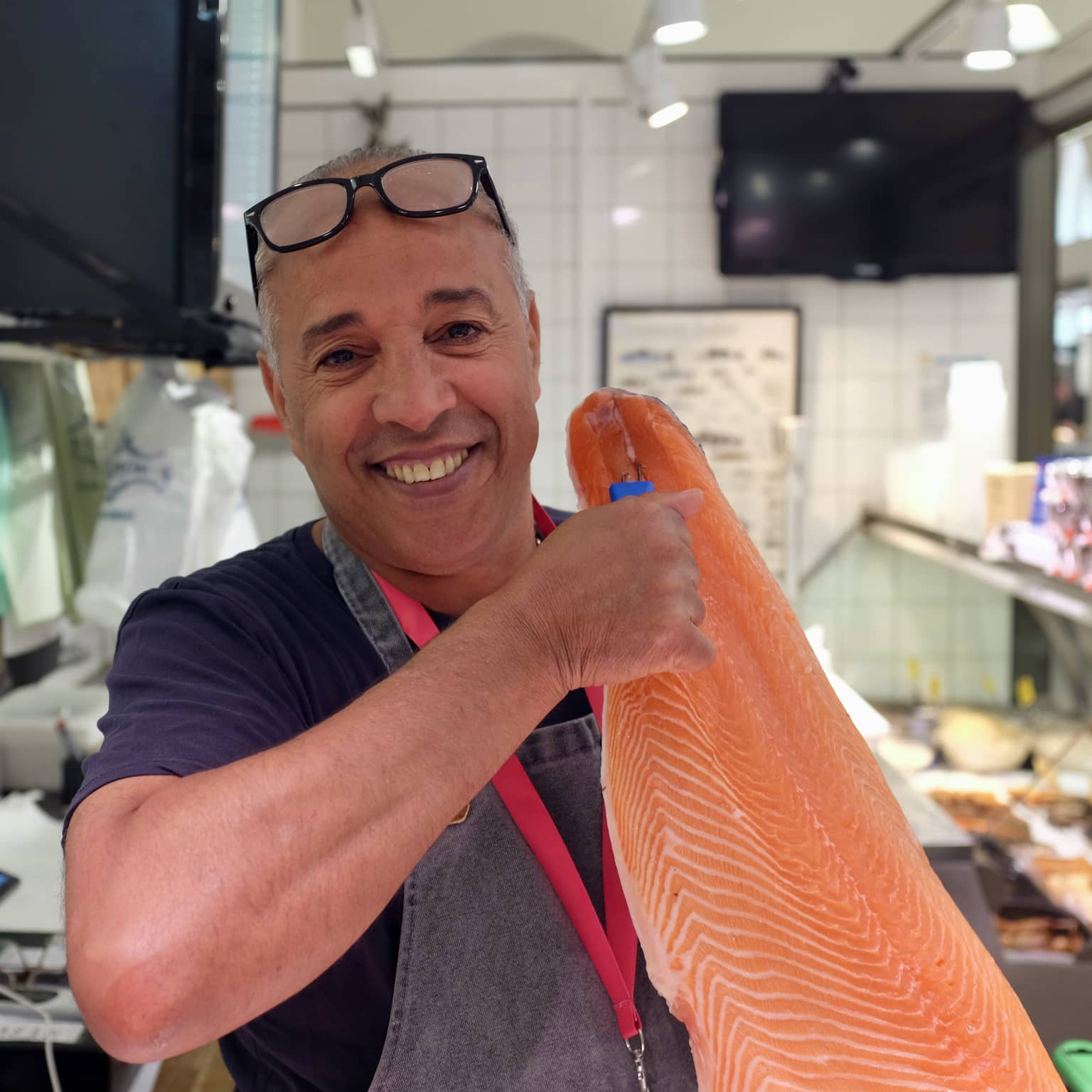 Fischhändler mit Lachs in der Markthalle
